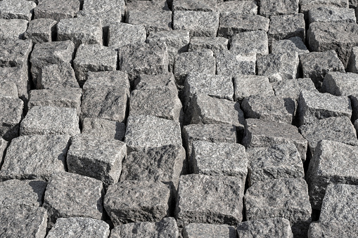 Group of granite cobblestone cubes and blocks next to one another as rustic stone background