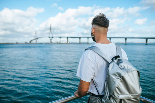 istock Man with backpack looking towards the sea 1988395046