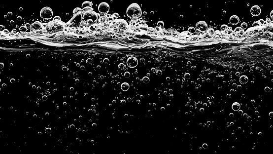 Abstract background with bubbles on a dark grey, in closeup. With copy space