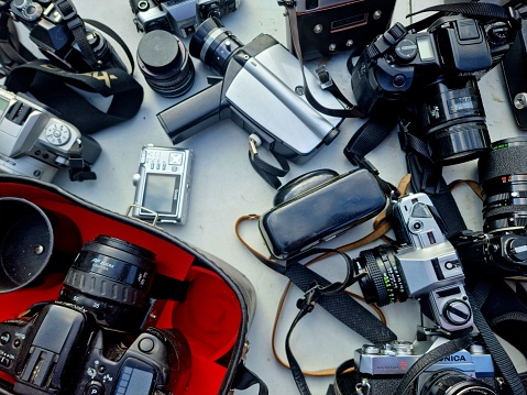 A couple of vintage cameras on a flea market. The image shows as close-up several old used photo cameras.