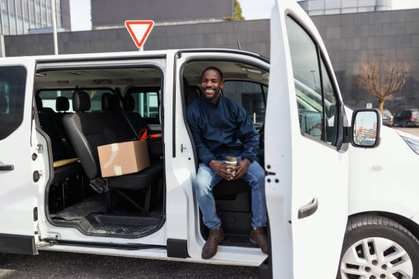 istock Smiling Delivery Man Seated in a Van 1988456370