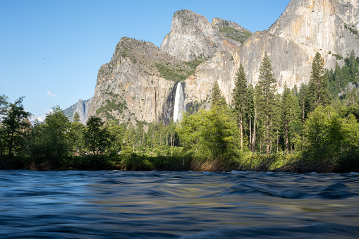 Merced River Smoothly Flows Below Roaring Bridalveil Falls in Yosemite