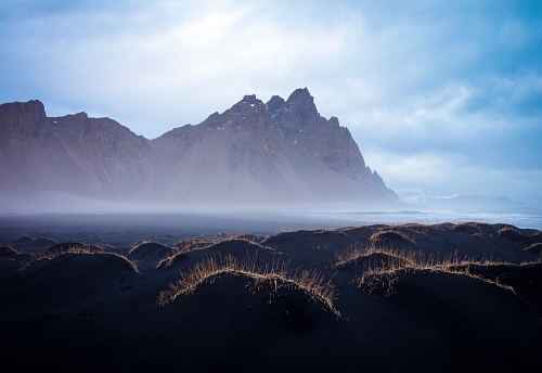 The Vesterhorn mountains rise out of the mist at dawn, South-Eastern Iceland