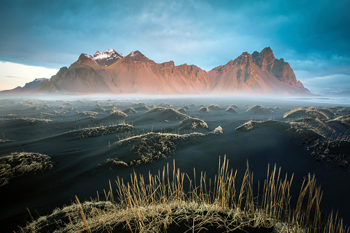 The Vesterhorn mountains rise out of the mist in early morning light, South-Eastern Iceland