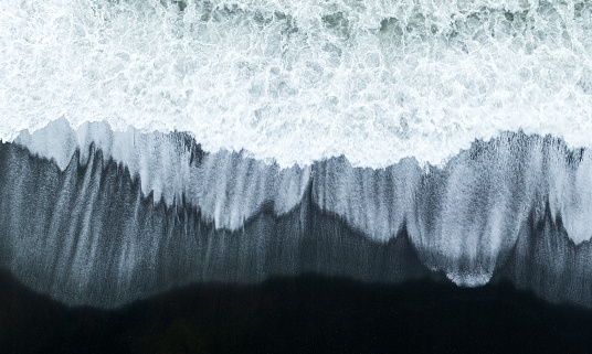 Bird's eye view of waves and seagulls on Iceland's black sand beaches