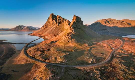 Aerial view of dramatic coastal mountain landscape and road in southern Iceland