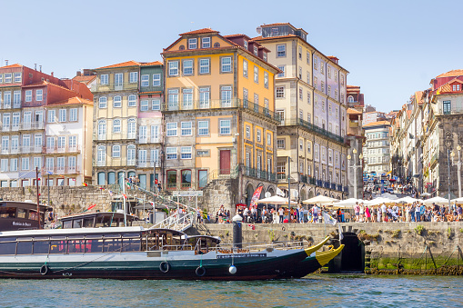 Porto, Portugal - 11 August, 2023: People walking at the Ribeira neighborhood. Ribeira's narrow cobblestone streets are dotted with small bars and restaurants serving classic Portuguese cuisine.