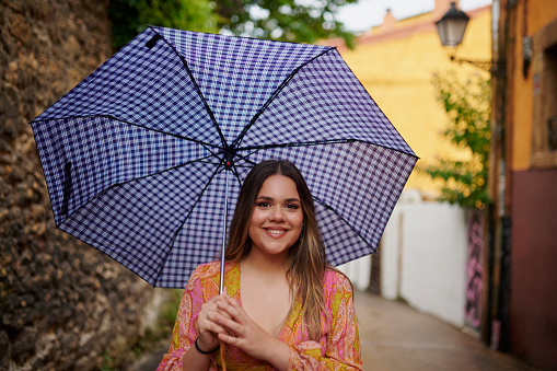 Happy woman, travel and portrait with umbrella in city street for walking, explore or adventure in Italy. Freedom, cover or plus size female person outdoor in Venice for holiday, journey or vacation