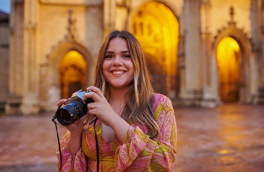 Portrait, travel and woman photographer In Italy with smile, holiday adventure and city in Europe. Photography, camera and face of happy girl on vacation with vintage architecture, memory and journey