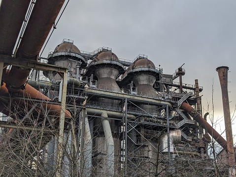 Old abandoned Ironworks are slowly taken over by nature. Rusted pipelines, machines and appliances.