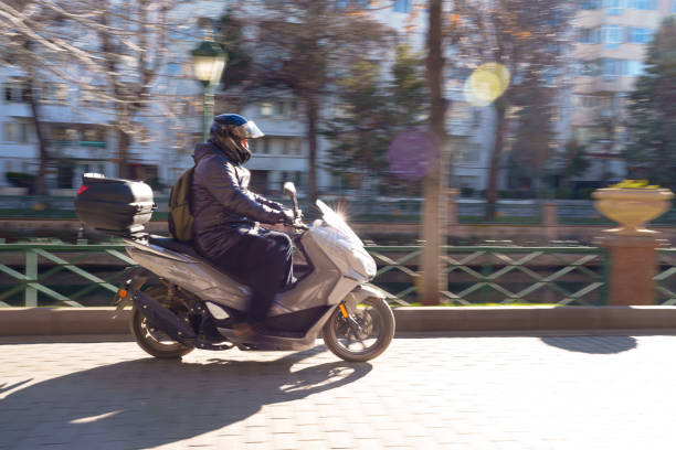 Long exposure pan photograph of man with his motorbike in streets