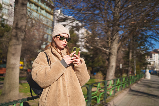 Woman using mobile phone in city