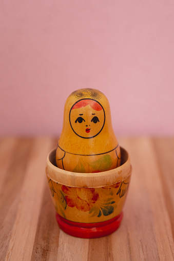 Traditional Russian nesting doll Matruskas lined up from the smallest to the biggest with mustard color background