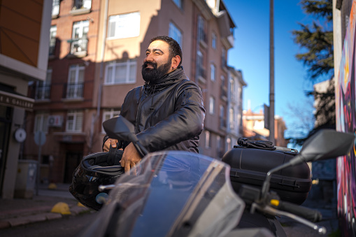 Man with his motorbike in streets