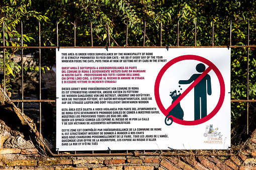 Roma, Latium - Italy - 11-21-2022: Warning sign in multiple languages prohibiting the feeding of cats to prevent road accidents