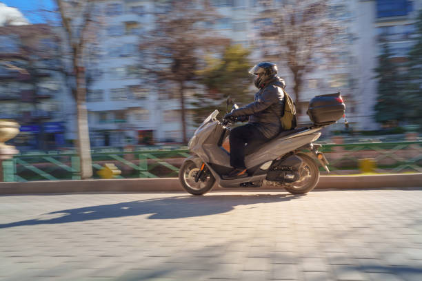 Long exposure pan photograph of man with his motorbike in streets