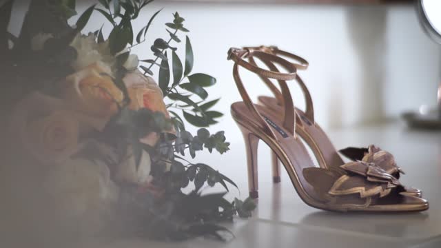 Video containing a bouquet of flowers and some wedding shoes.