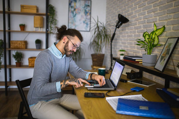 istock Young man doing his finances at home office 1988618545