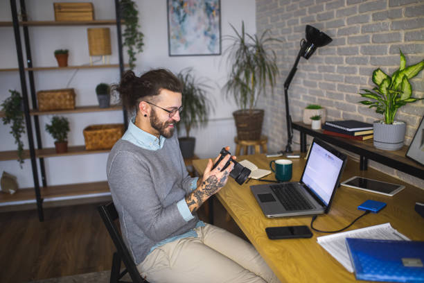 istock Young man photographer looking at images on camera while working in studio 1988621617
