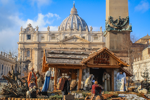 Vatican City (Rome- Italy) - December 2019: Christmas tree at St Peter's Square in front of St Peter's Basilica. Part of the Obelisco Piazza San Pietro Città del Vaticano (the Vatican Obelisk) can be seen, as well as the annual nativity scene.