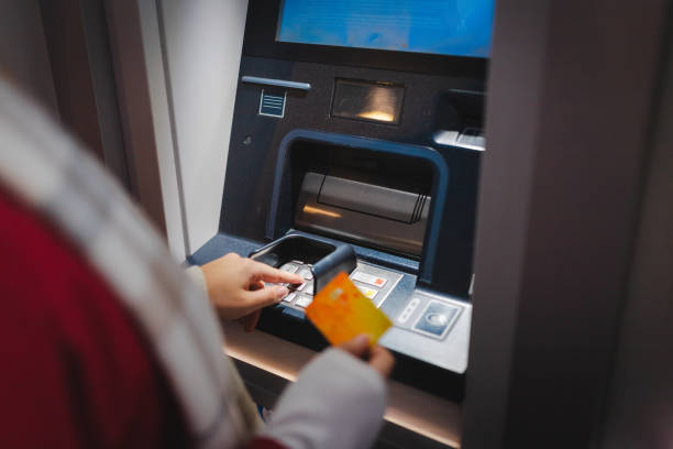 istock Close-up of a young woman using an ATM machine 1988647045