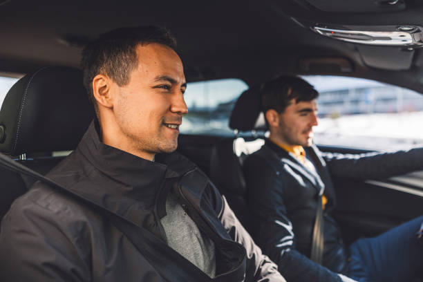 istock Driver transporting a business man on a crowd sourced taxi 1988673510