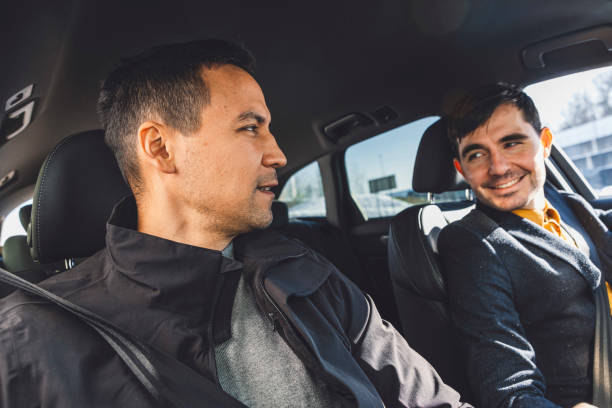 istock Driver transporting a business man on a crowd sourced taxi 1988673516