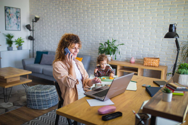 istock Young mother working from home while taking care of her baby 1988673743