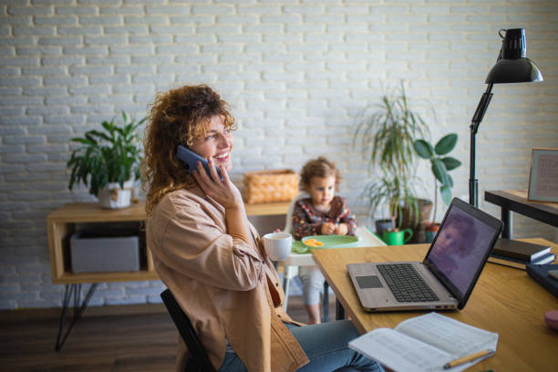 istock Young mother working from home while taking care of her baby 1988673772