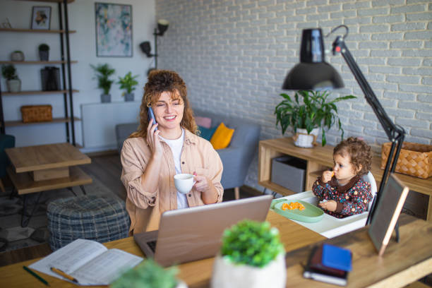 istock Young mother working from home while taking care of her baby 1988684620