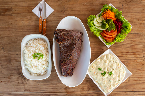 Brazilian barbecue with complements - Salad, vegetable mayonnaise, rice and fries
