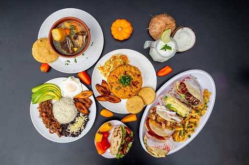 knolling of Colombian dishes - arepas, pabellon criollo, rib soup and rice with chicken