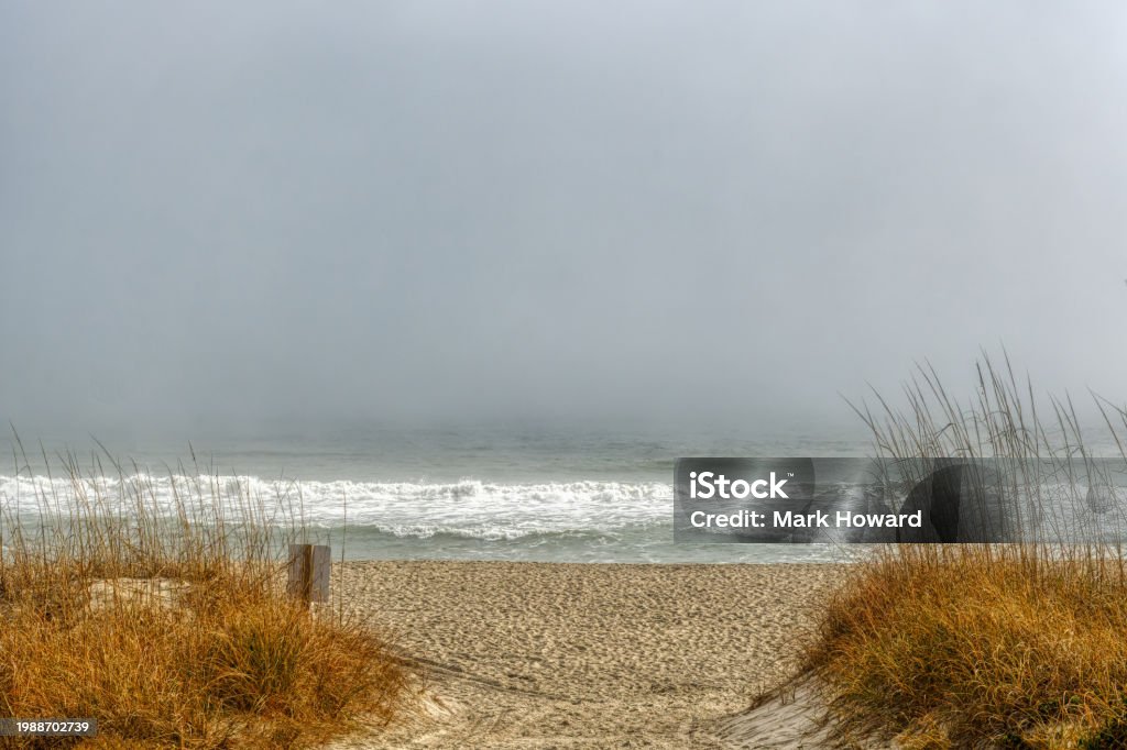 Foggy Ocean Beach Landscape A foggy coastal landscape of a sandy beach entrance in Wilmington, North Carolina in HDR. Alternative Therapy Stock Photo