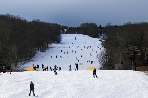 West Dover, Vermont, USA - 31 January 2023: Many skiers and snowboarders enjoying New Years Eve day on the slopes of Mt. Snow in Vermont USA.