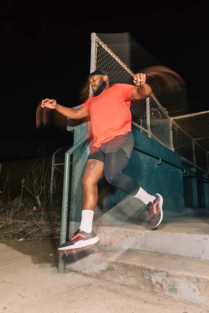 black man mid-air while running in los angeles at night - city night lighting equipment mid air imagens e fotografias de stock