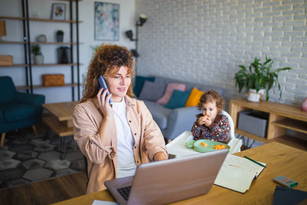 istock Young mother working from home while taking care of her baby 1988736979
