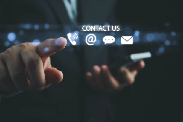istock Contact us or Customer support hotline, people connect. Businessman touching on virtual screen contact icons (email, address, live chat, telephone). Customer service, helpdesk advice online support. 1988745778