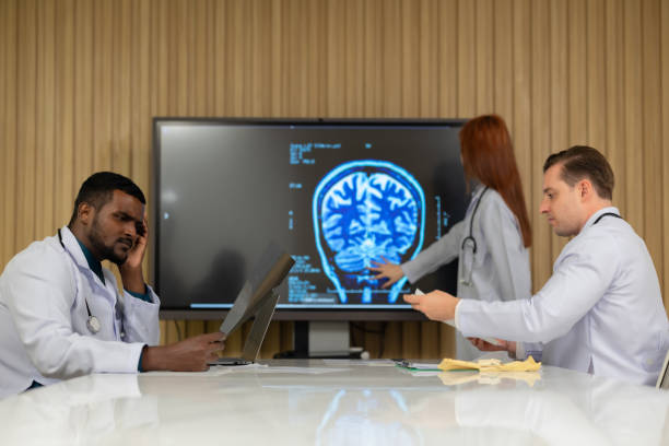 equipe médica multicultural discutindo filme de rm de pacientes em ambiente hospitalar - neuroscience mri scan brain brain surgery - fotografias e filmes do acervo