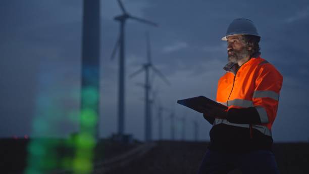 istock Engineer works with HUD holographic in wind farm. Night shift. 1988797810