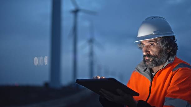 istock Engineer works with HUD holographic in wind farm. Night shift. 1988798310