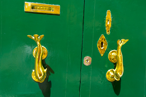 Marsaxlokk, Malta - September 14, 2012: Traditional handle and doorknocker made of brass in the form of fish on the doors of old houses in Malta