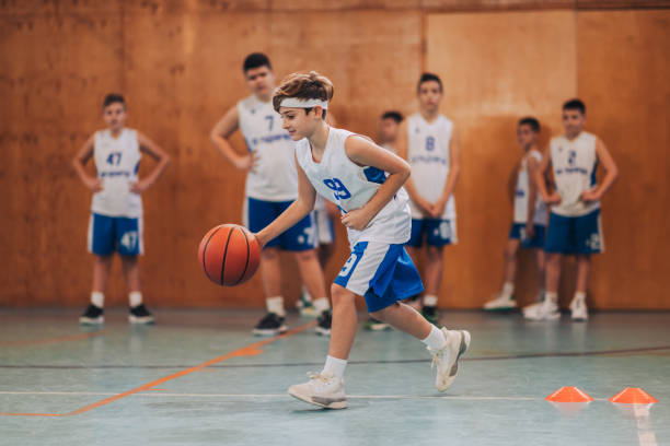 istock A junior basketball player dribbling a ball and practicing on court. 1988812136