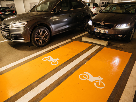 Strasbourg, France - Jan 7, 2021: Skoda and Audi SUV cars parked inside underground parking with two special places for motorcycle