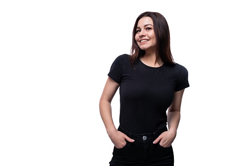 Confident beautiful young brunette woman in black t-shirt on white clean background.