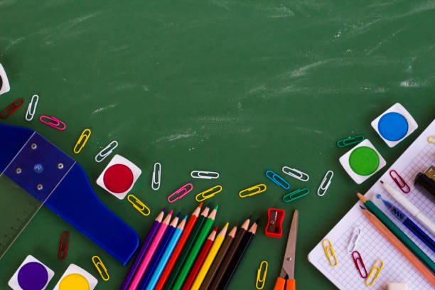 istock School supplies on greenboard with chalk dust trail and copy space. 1988834195