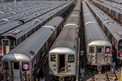 NYC subway trains appear to stretch to infinity in this image at Hudson Yards taken in April 2017. At that time, the subway yard was below street level in open air. Since then, the yard has been covered over by the development of Hudson Yard, which includes several skyscrapers and high end retail shopping. The development of Hudson Yards was the largest US real estate development since Rockefeller Center in the early 1930s.