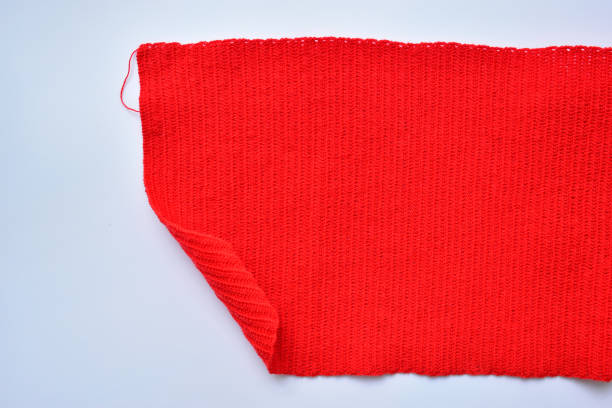 istock red wool knitted yarn texture, woolen fabric on white background 1989117668