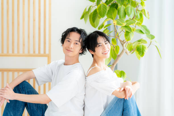 istock Young couple sitting close together back to back 1989135553
