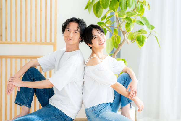 istock Young couple sitting close together back to back 1989135556