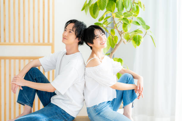 istock Young couple sitting close together back to back 1989135557